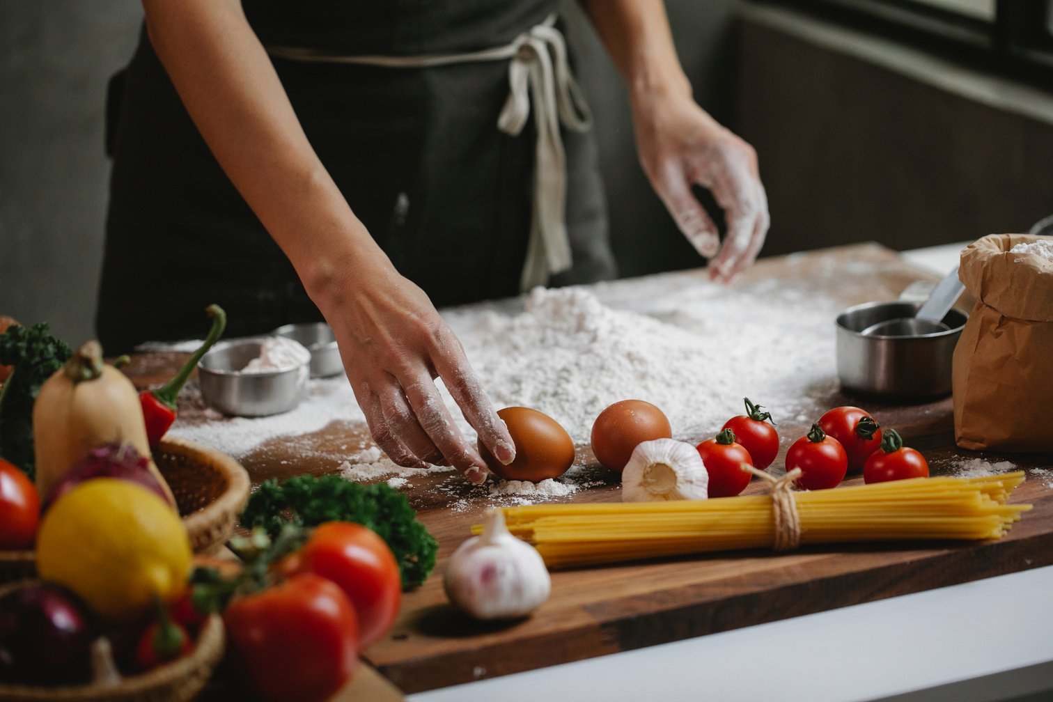 Cook preparing food dish standing at table with different ingredients